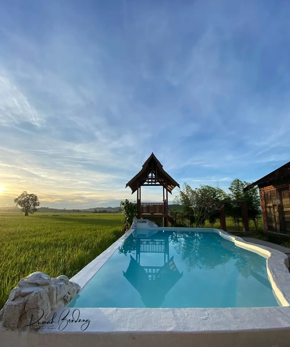 Pool and gazebo reflecting the evening sky at Rumah Bendang