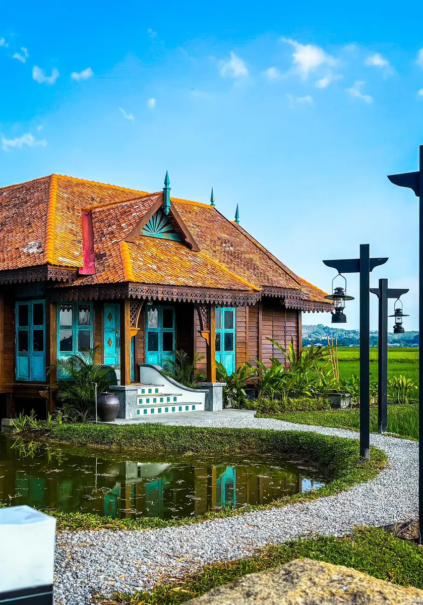 Turquoise porch and tiled front steps of Rumah Uda under a blue sky